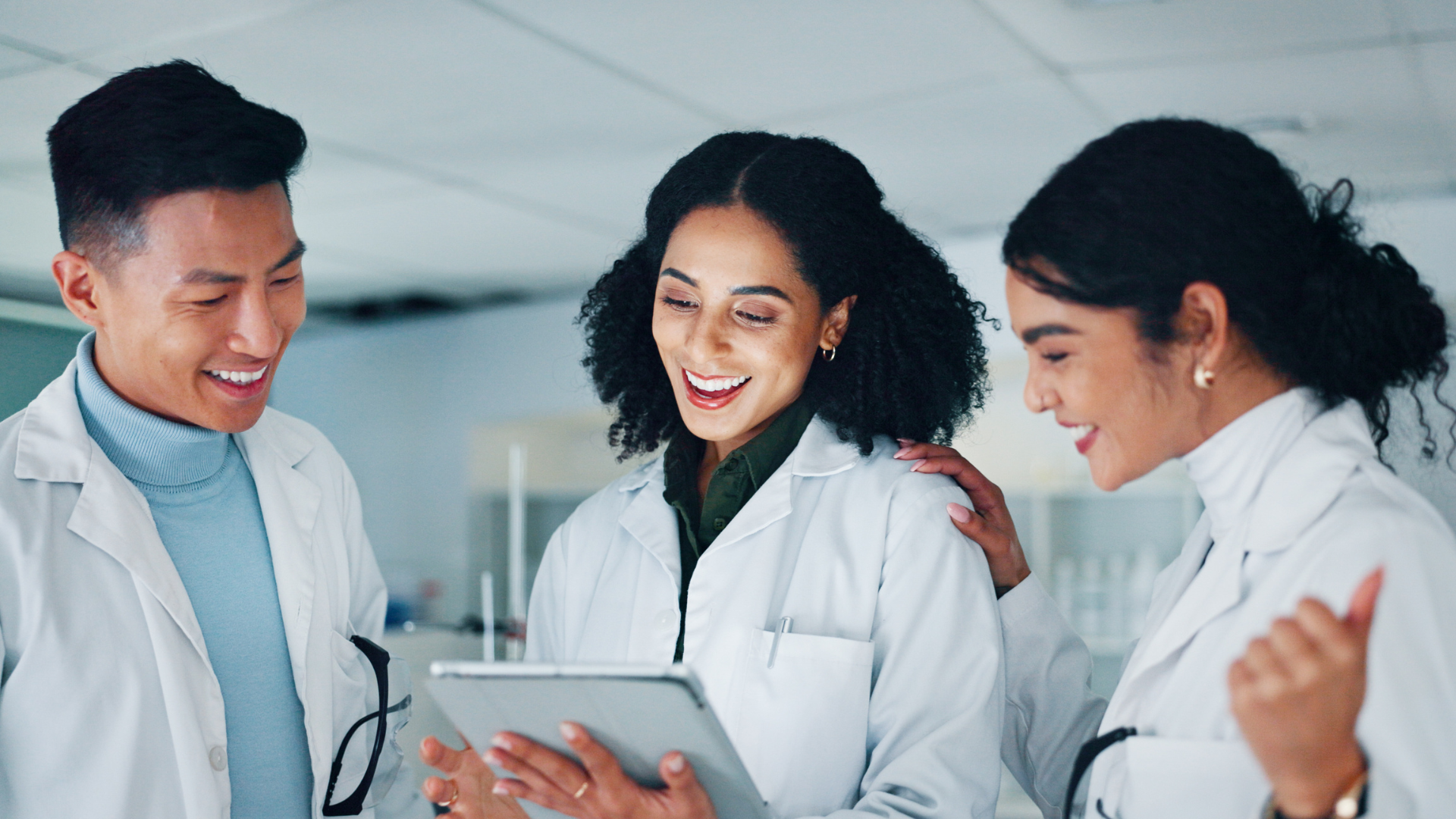 Team van laboranten bespreekt farmaceutische onderzoeksresultaten op tablet; bekijk onze pharma vacatures.